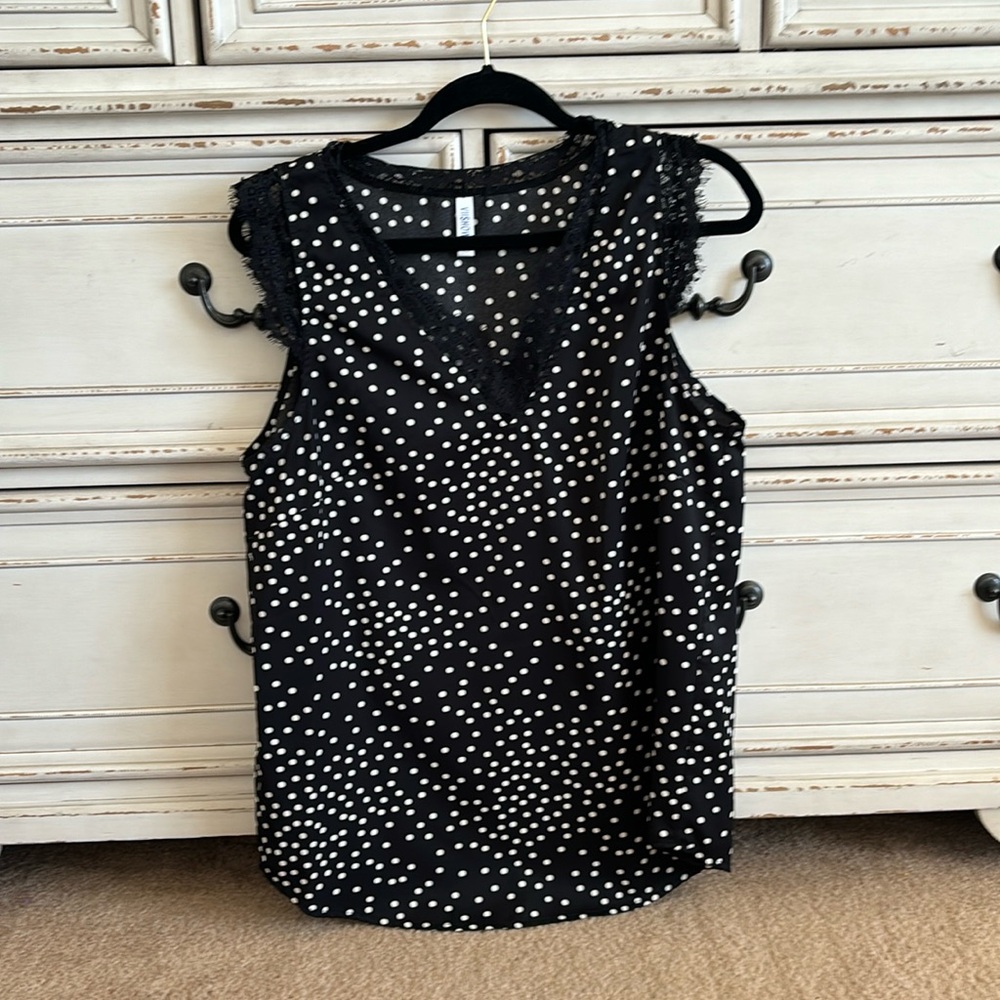 Black sleeveless blouse with white polka dots